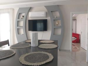a living room with a table with a tv on the wall at Villa Ayla in Fethiye