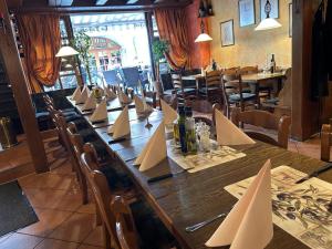 a long table in a restaurant with napkins on it at Hotel Iris- Pizzeria Ristorante La Taverna in Meersburg
