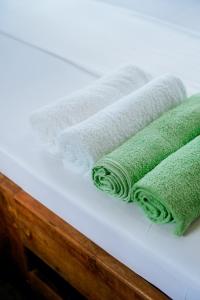 three green towels sitting on top of a table at Kanga Beach Paradise in Mafia Island