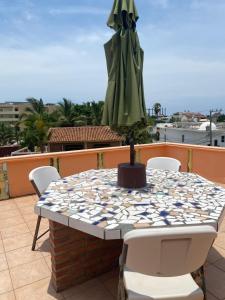 a table and chairs on a balcony with a umbrella at Casitas Las Palmas - Nacar - Mother of Pearl in Punta Mita