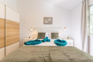 Un dormitorio con una cama grande con almohadas azules. en El Refugio de Agueda, en San Bartolomé 35 fotos más