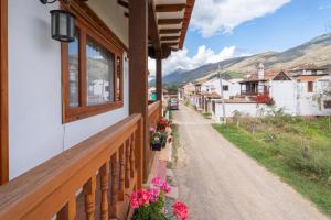 einen Balkon eines Hauses mit Blumen auf einer Straße in der Unterkunft BALCON DE CHIE in Villa de Leyva