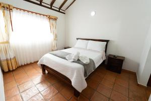 ein Schlafzimmer mit einem Bett und einem Handtuch darauf in der Unterkunft BALCON DE CHIE in Villa de Leyva