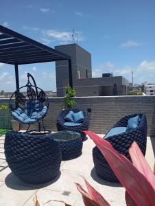 a group of chairs sitting on top of a roof at Flat com piscina na cobertura em Intermares in Cabedelo +14 photos