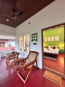 a room with a bench and a bed and a table at 4elementis beach homestay in Mararikulam