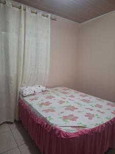 um quarto com uma cama com uma colcha florida em Casa Sobrado em Cuiabá