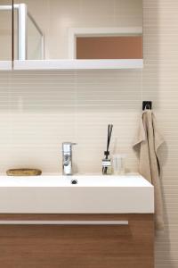 クノック・ヘイストにあるA Bien Venueの白い洗面台と鏡のあるバスルーム