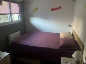 ein Schlafzimmer mit einem Bett mit violetter Bettwäsche und einem Fenster in der Unterkunft Gîte Le Rêve, Entre Lac Et Montagne in Viviers-du-Lac
