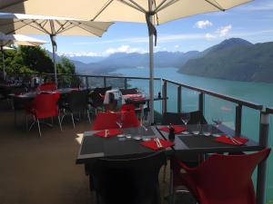 ein Restaurant mit Tischen und Stühlen und Seeblick in der Unterkunft Gîte Le Rêve, Entre Lac Et Montagne in Viviers-du-Lac