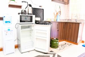a kitchen with an open refrigerator and a microwave at Luxe-homestay 1 Bed Executive Studio in Eldoret