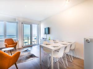 a white dining room with a table and chairs at LaVue premier in Galopen