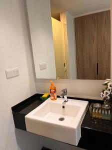 a bathroom with a white sink and a mirror at AnR Studio Suite Inside H Elite Building in Kota Bharu