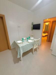 einen Esstisch mit 2 Tellern und 2 Stühlen in der Unterkunft 3 Bedroom Apartment in Portimão, Algarve by Salam Stays in Portimão