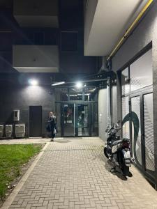 a motorcycle parked outside of a building at night at Apartman ANIR in Novi Sad