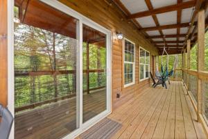 RogersにあるHot Tub & WiFi - Clifftop Cabin - Muir Valleyのベンチが置かれた木造キャビンの網戸付きポーチ