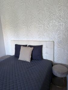 een bed met een blauw dekbed en een muur bij Apartamento Machadinho in Vale de Pedras +13 foto's