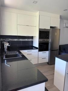 een keuken met witte kasten en roestvrijstalen apparaten bij Apartamento Machadinho in Vale de Pedras