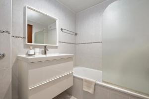 a white bathroom with a sink and a bath tub at Piornais by Homie in Panasqueira +18 photos