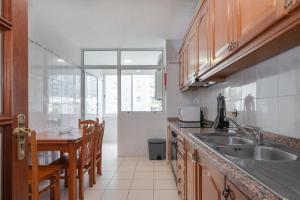 a kitchen with a sink and a table with chairs at Piornais by Homie in Panasqueira
