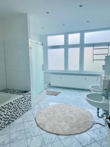 a bathroom with three sinks and a shower and a tub at Private Room in Shared Apartment in Berlin