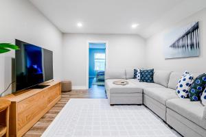 a living room with a couch and a flat screen tv at BRAND NEW, fully furnished 3 bedroom, 3 bathroom home in Ocean Springs! in Gulf Hills
