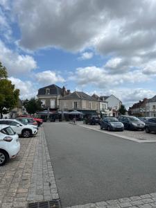 un estacionamiento con autos estacionados al lado de una calle en Sous les Toits de Boussac, en Boussac
