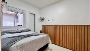 a bedroom with a bed and a large window at Casa pertinho do mar in Capão da Canoa