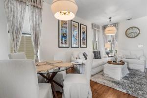 海泉市Pelican Cove Cottage located Downtown Ocean Springs的客厅配有白色家具和桌子