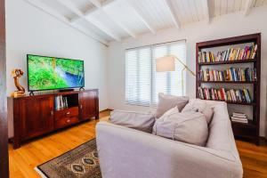 a living room with a white couch and a tv at Chalet Lulu with Solar Power and Hot Tub in Guaynabo in Puerto Nuevo
