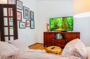 a living room with a flat screen tv on a wooden entertainment center at Chalet Lulu with Solar Power and Hot Tub in Guaynabo in Puerto Nuevo