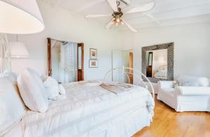 a white bedroom with a white bed and a couch at Chalet Lulu with Solar Power and Hot Tub in Guaynabo in Puerto Nuevo