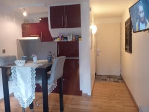 a kitchen with a table and chairs and a kitchen with a kitchen gmaxwell gmaxwell gmaxwell at Le briochin in Saint-Brieuc