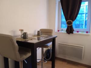 a table in a room with two chairs and a window at Le briochin in Saint-Brieuc +2 photos