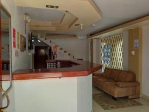 a kitchen with a bar and a couch in a room at Hotel Mirador in La Joya de los Sachas