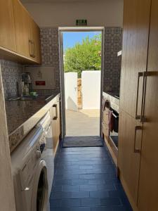 eine Küche mit einer Tür, die in eine Küche mit einer Waschmaschine führt in der Unterkunft Villa Valentina in Carvoeiro + 33 Fotos