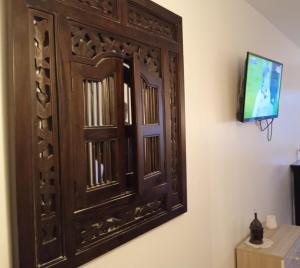 a wooden door on a wall with a television at Le briochin in Saint-Brieuc