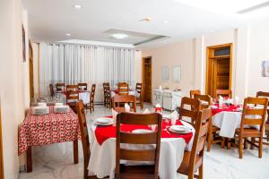 un restaurant avec tables et chaises et nappes rouges et blanches dans l'établissement CASA BETANIA Musanze Karwasa, à Gasanze