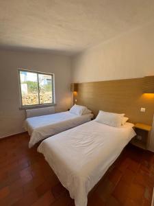 zwei Betten in einem Zimmer mit Fenster in der Unterkunft Villa Valentina in Carvoeiro
