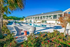 a resort with a pool and chairs and a building at BRAND NEW, fully furnished 3 bedroom, 3 bathroom home in Ocean Springs! in Gulf Hills