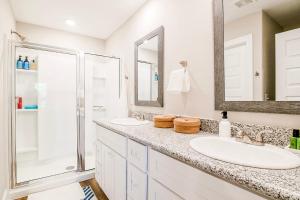 a white bathroom with two sinks and a shower at BRAND NEW, fully furnished 3 bedroom, 3 bathroom home in Ocean Springs! in Gulf Hills +39 photos