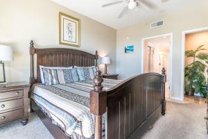 une chambre avec un grand lit en bois et une commode dans l'établissement Beachview Condo at Legacy Tower 1 -202 - fully furnished 2 bedroom 2 bathroom, à De Buys 24 autres photos