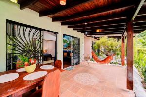 een eetkamer met een tafel en een patio bij Villas Kiki in Puerto Viejo