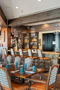 un restaurant avec des tables et des chaises en bois et un bar dans l'établissement The Ritz-Carlton Club, Ski-in & Ski-out Resort in Aspen Highlands, 3 Bedroom Residence Float 5, à Aspen