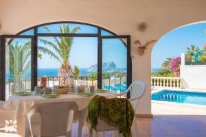 ein Esszimmer mit Tisch und Blick auf das Meer in der Unterkunft Villa Albatros by Abahana Villas in Benissa