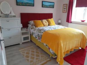 1 dormitorio con 1 cama con manta amarilla y vestidor en 1-Bed Seaside Retreat - Sleeps 2 Parking & Garden, en Peacehaven