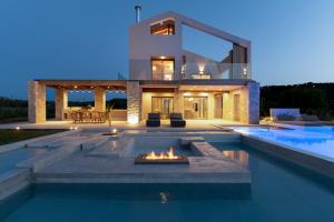 a house with a fire pit in front of a swimming pool at Allure Wellness Retreat in Lefkada