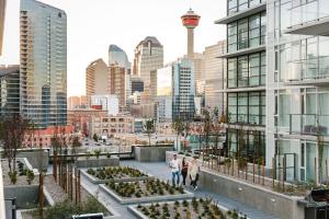 twee mensen lopen over een stoep in een stad bij Downtown Calgary Modern 1BR with Pullout couch in Calgary