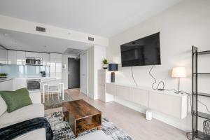 een woonkamer met een bank en een tv bij Downtown Calgary Modern 1BR with Pullout couch in Calgary