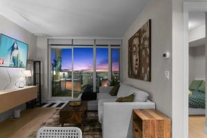 een woonkamer met een witte bank en een groot raam bij Downtown Calgary Modern 1BR with Pullout couch in Calgary