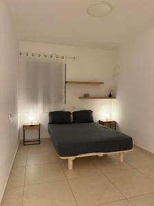 Un dormitorio con una cama y dos mesitas de noche sobre dos mesas en מיני פנטהאוס נווה גן Mini Penthouse by Lake Neve Gan, en Petaj Tikva